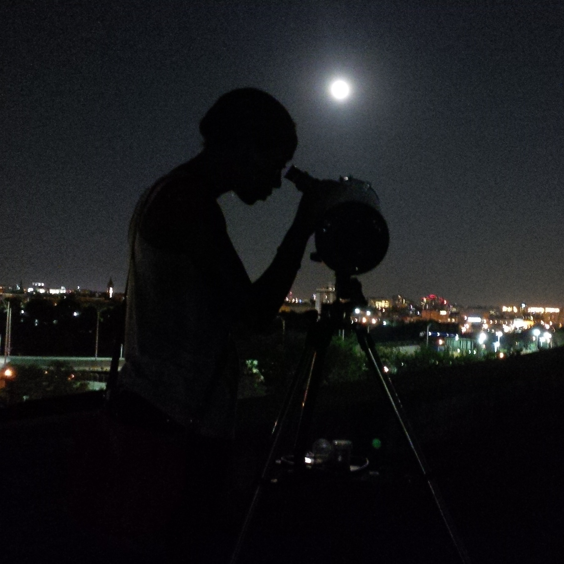Denia Taylor looks at the full moon near the city of Lowell, Massachusetts